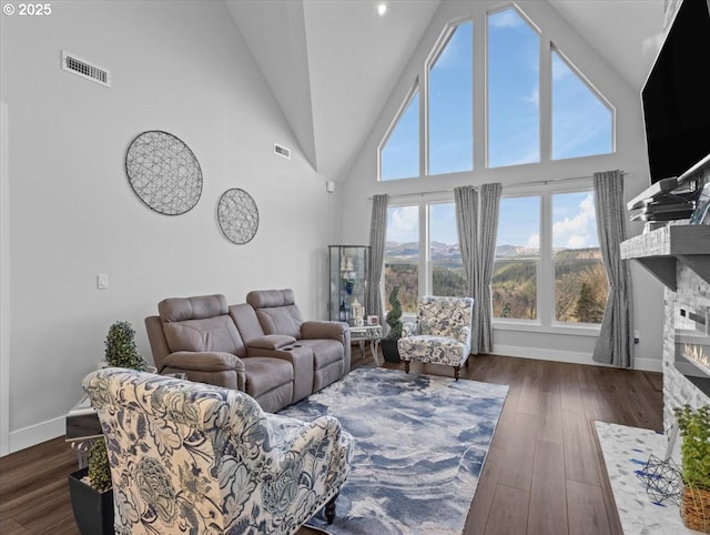 living room with dark hardwood / wood-style flooring, a fireplace, and high vaulted ceiling