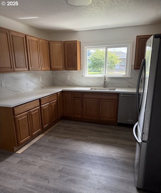 1640 Manor Dr, Gladstone, OR 97027 - kitchen with appliances with stainless steel finishes, dark wood-style flooring, decorative backsplash, and a textured ceiling