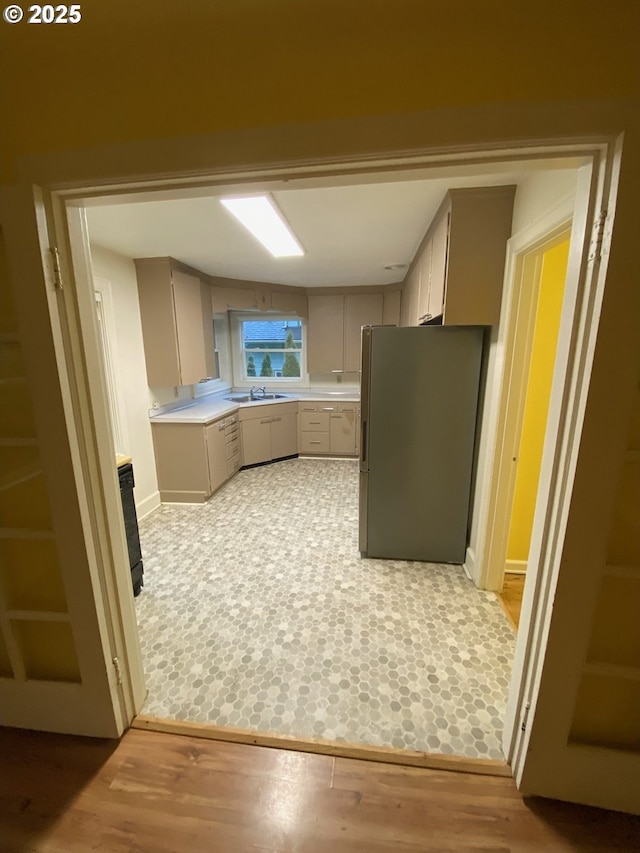 564566 Alameda Ave, Astoria, OR 97103 - kitchen featuring freestanding refrigerator, a sink, light countertops, and gray cabinetry