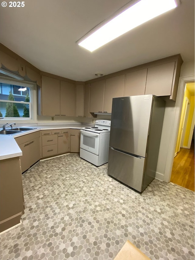 564566 Alameda Ave, Astoria, OR 97103 - kitchen with freestanding refrigerator, white electric range oven, a sink, light countertops, and gray cabinetry