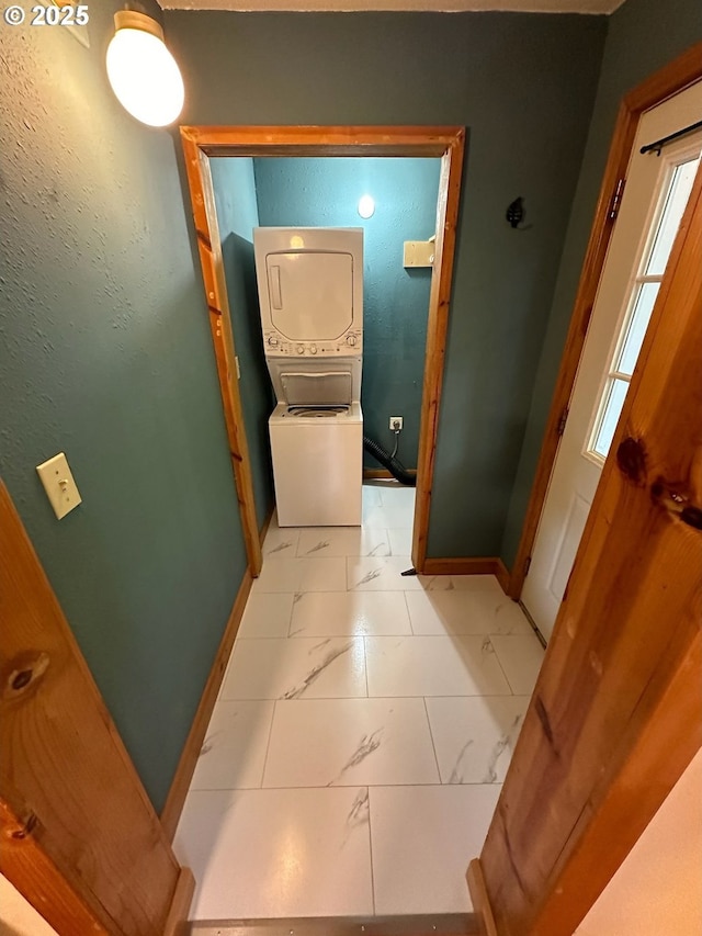 564566 Alameda Ave, Astoria, OR 97103 - hall featuring stacked washing machine and dryer, light marble finish flooring, and baseboards