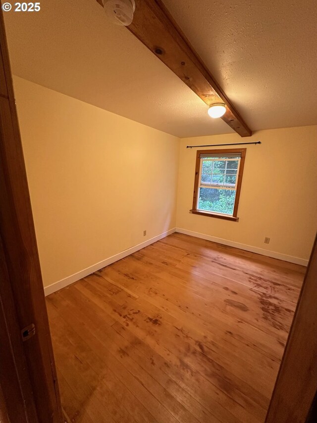 564566 Alameda Ave, Astoria, OR 97103 - unfurnished room with light wood-type flooring, beam ceiling, a textured ceiling, and baseboards
