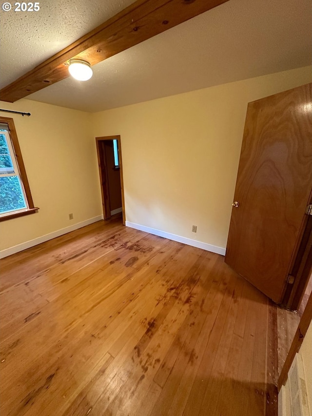564566 Alameda Ave, Astoria, OR 97103 - spare room featuring light wood-type flooring, beam ceiling, and baseboards