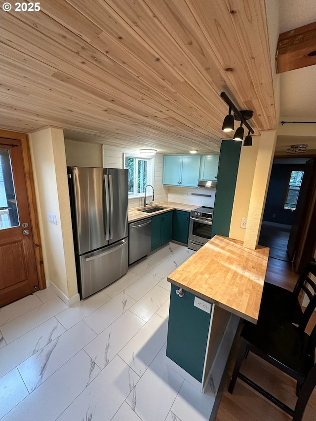 564566 Alameda Ave, Astoria, OR 97103 - kitchen with stainless steel appliances, a sink, light marble finish floors, a peninsula, and wood ceiling