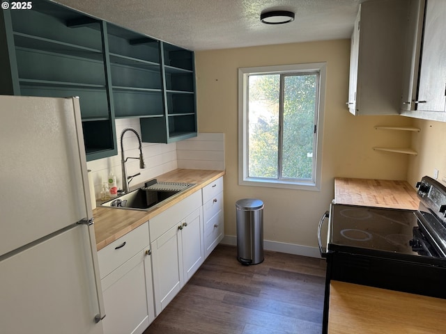 564566 Alameda Ave, Astoria, OR 97103 - kitchen with freestanding refrigerator, black / electric stove, a sink, open shelves, and dark wood-type flooring