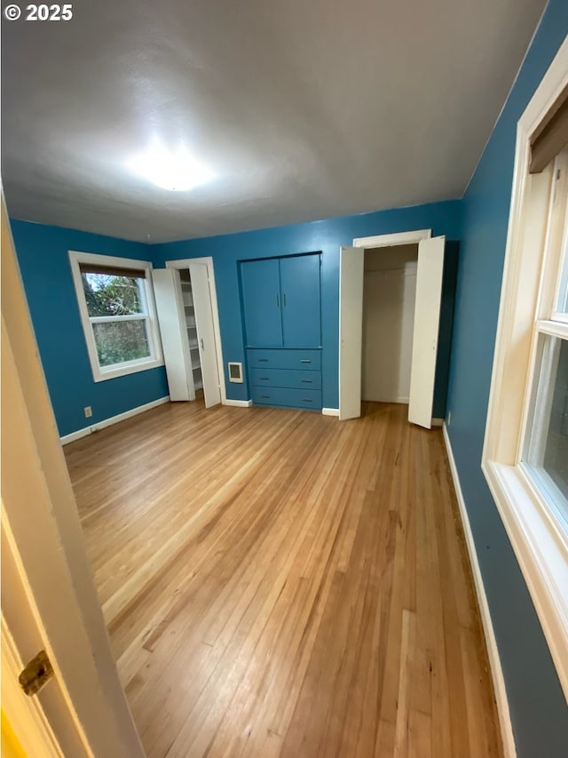 564566 Alameda Ave, Astoria, OR 97103 - unfurnished bedroom with light wood-style floors, baseboards, and multiple closets