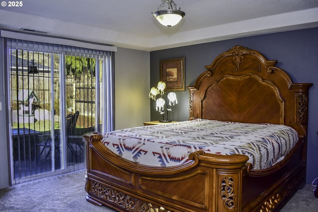 bedroom with carpet floors, access to outside, and a tray ceiling