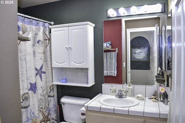 bathroom with walk in shower, vanity, and toilet