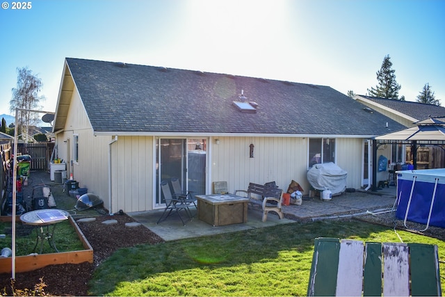 back of property with a gazebo, an outdoor fire pit, a yard, and a patio area