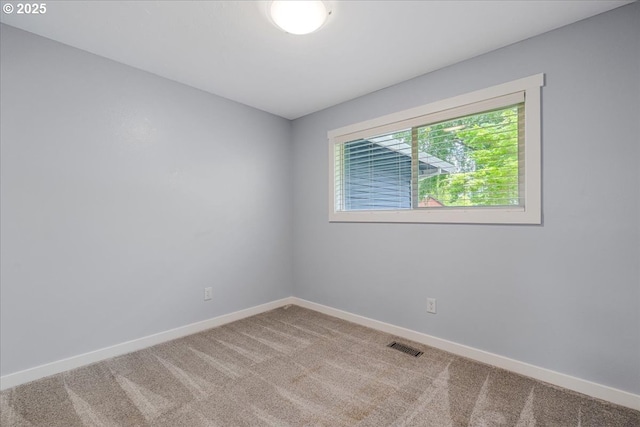 carpeted spare room with baseboards and visible vents