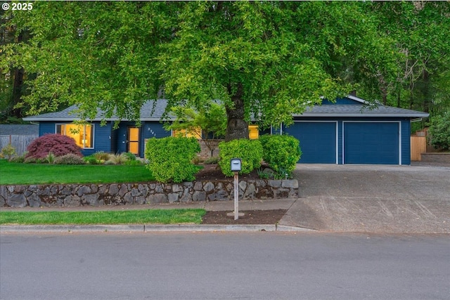 view of front of house with an attached garage, fence, roof with shingles, and concrete driveway