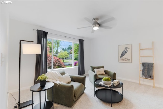carpeted living area featuring a ceiling fan and baseboards