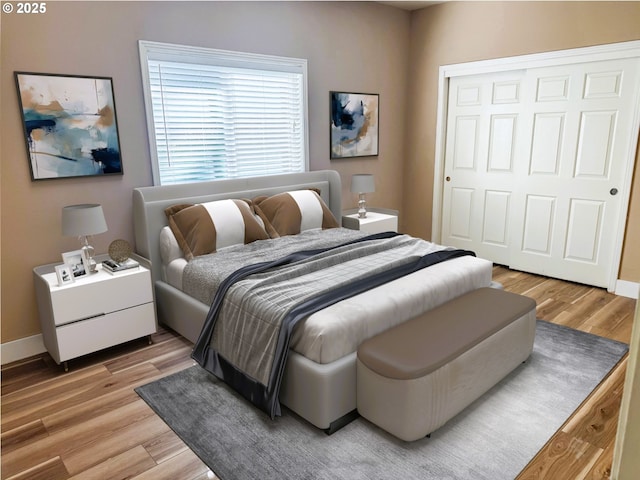 bedroom featuring light wood-style floors, baseboards, and a closet