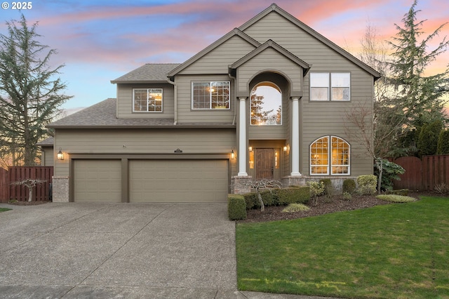 view of front property featuring a garage and a yard