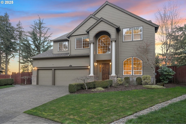 front facade with a garage and a yard