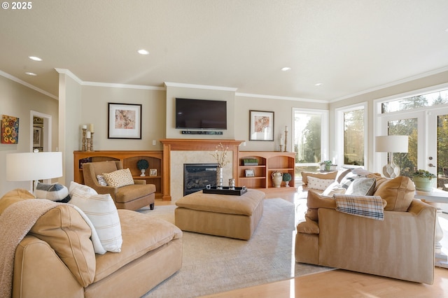 living room featuring crown molding, a premium fireplace, and light hardwood / wood-style floors