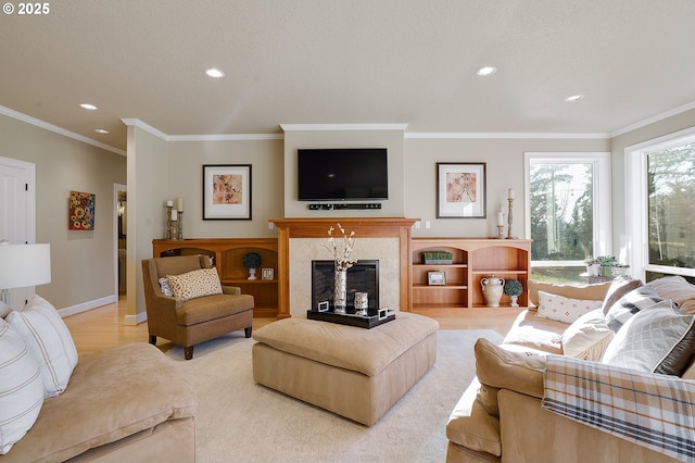 living room featuring ornamental molding, light wood-type flooring, and a high end fireplace