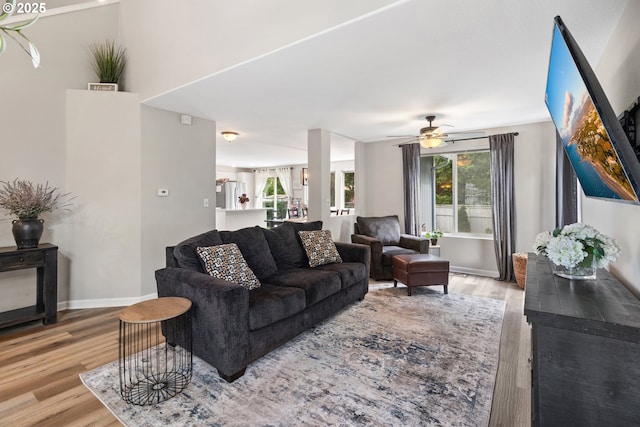 living room featuring wood finished floors, baseboards, and ceiling fan