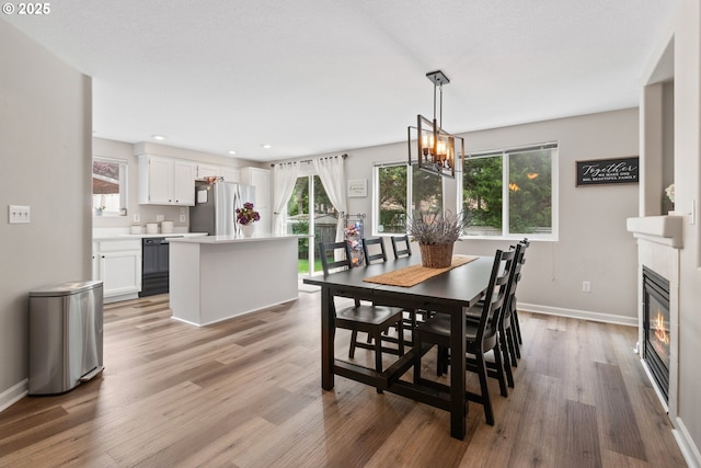 dining room featuring plenty of natural light, light wood finished floors, baseboards, a chandelier, and recessed lighting