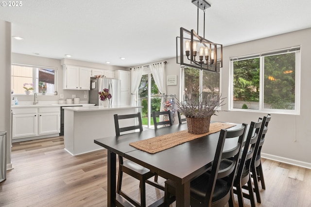 dining area featuring light wood-type flooring, a chandelier, recessed lighting, and baseboards