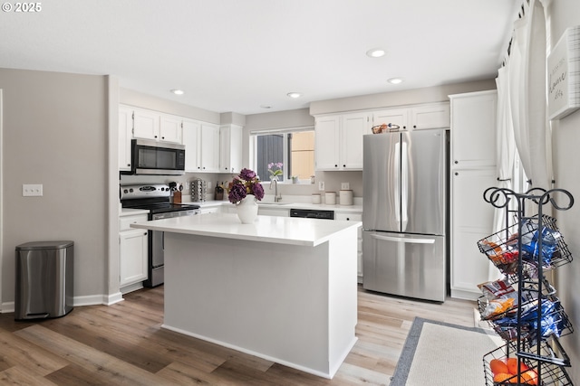 kitchen featuring stainless steel appliances, white cabinetry, light countertops, light wood-style flooring, and recessed lighting