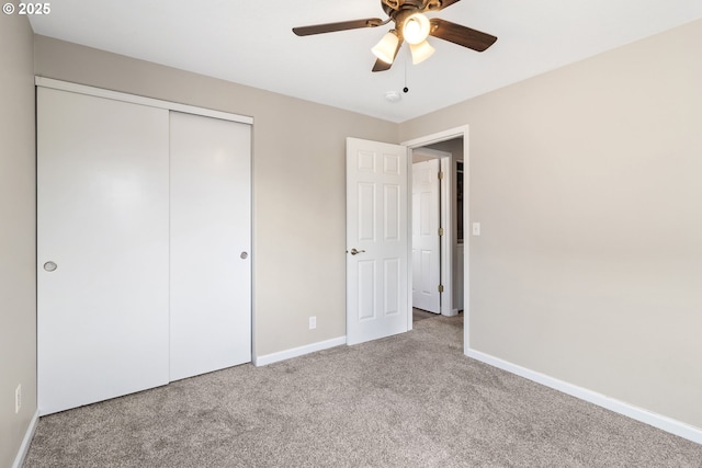 unfurnished bedroom with carpet floors, baseboards, a closet, and a ceiling fan