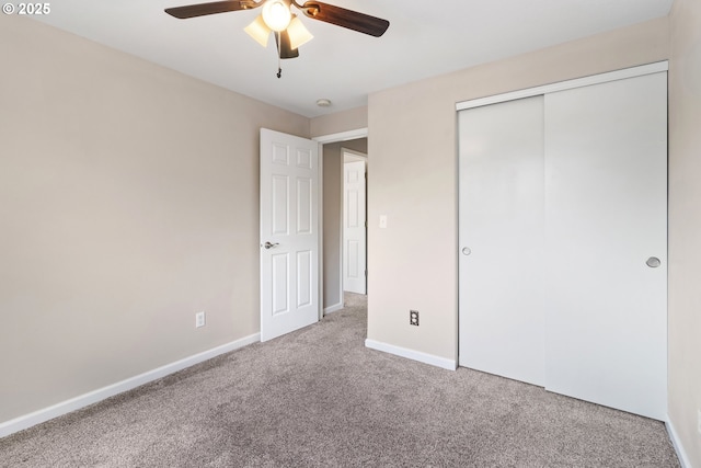 unfurnished bedroom with carpet floors, baseboards, a closet, and ceiling fan