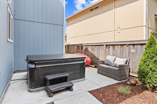 view of patio / terrace featuring a hot tub and a fenced backyard
