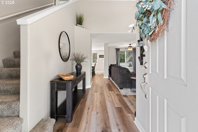 entryway featuring stairway, wood finished floors, and a ceiling fan