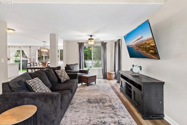 living room with light wood-style floors, healthy amount of natural light, and a chandelier