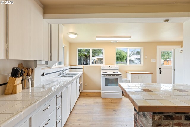 1548 Harlan St, Roseburg, OR 97471 - kitchen with white range with electric stovetop, tile counters, light wood-type flooring, plenty of natural light, and crown molding