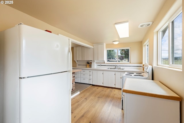 1548 Harlan St, Roseburg, OR 97471 - kitchen featuring white appliances, light wood-style flooring, white cabinets, and light countertops