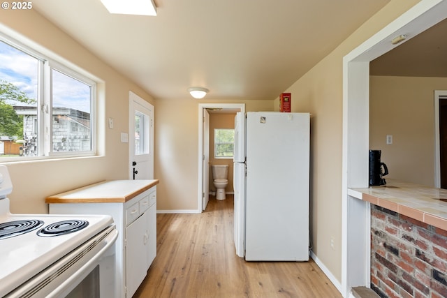 1548 Harlan St, Roseburg, OR 97471 - kitchen with white appliances, light wood finished floors, white cabinets, light countertops, and plenty of natural light