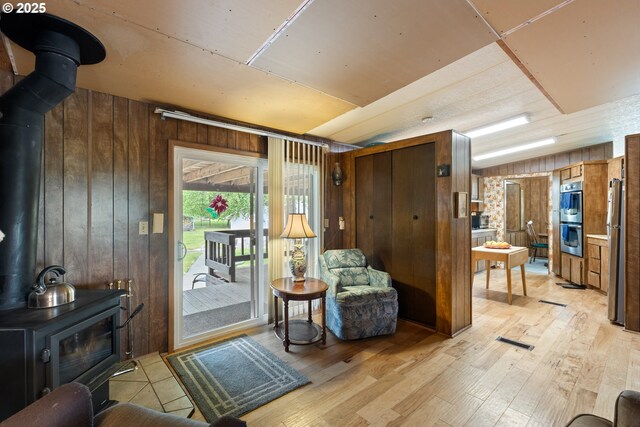 1548 Harlan St, Roseburg, OR 97471 - sitting room with a wood stove, wooden walls, and light wood finished floors