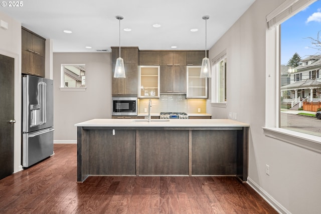 kitchen featuring light countertops, appliances with stainless steel finishes, dark wood-style floors, modern cabinets, and a sink