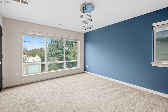 carpeted spare room featuring visible vents and baseboards