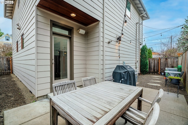 view of patio featuring outdoor dining area, a fenced backyard, and grilling area