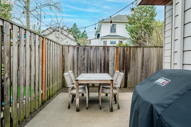 view of patio featuring grilling area, a fenced backyard, and outdoor dining space