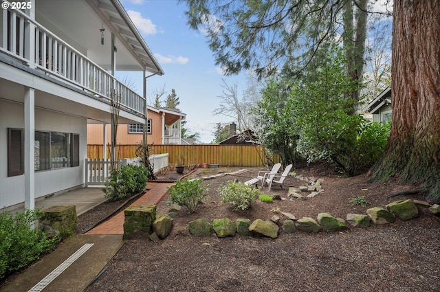 view of yard with a patio area, a balcony, and fence