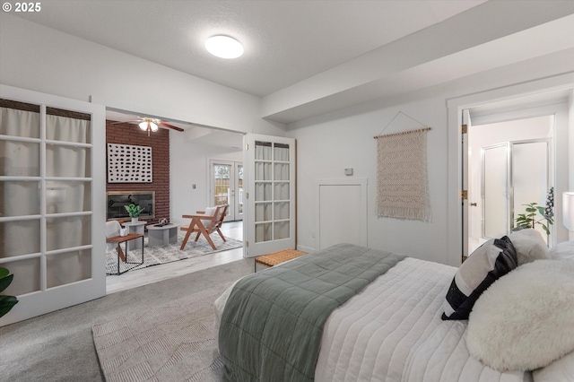 bedroom featuring carpet flooring, french doors, and a glass covered fireplace