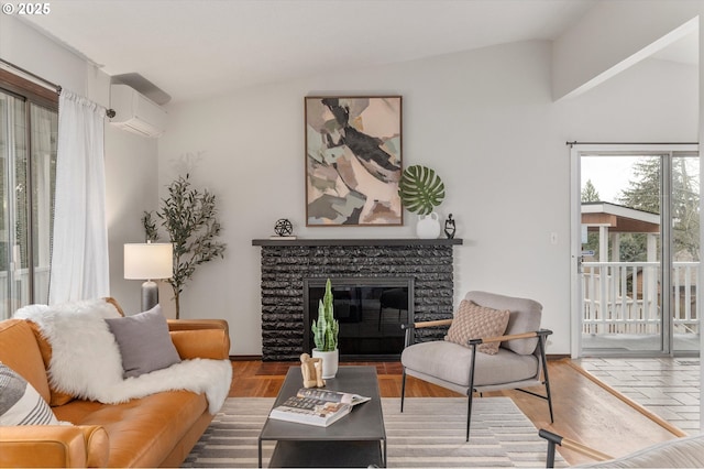 living room featuring a fireplace, a wall mounted AC, lofted ceiling, and wood finished floors