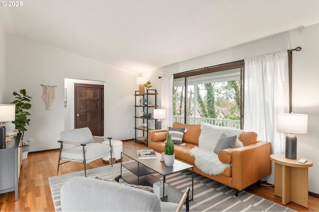 living area featuring vaulted ceiling and light wood-style flooring