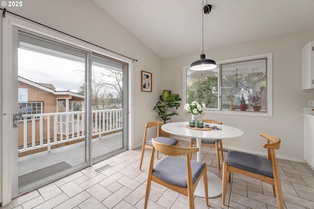 dining area featuring visible vents, baseboards, and vaulted ceiling