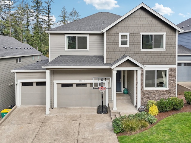 view of front of house featuring stone siding, roof with shingles, and driveway