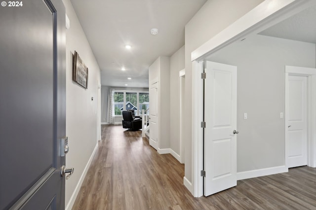 hall featuring recessed lighting, wood finished floors, and baseboards