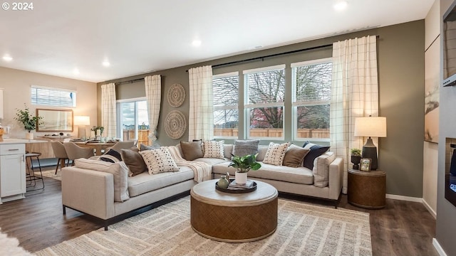 living area with baseboards, recessed lighting, and dark wood-type flooring