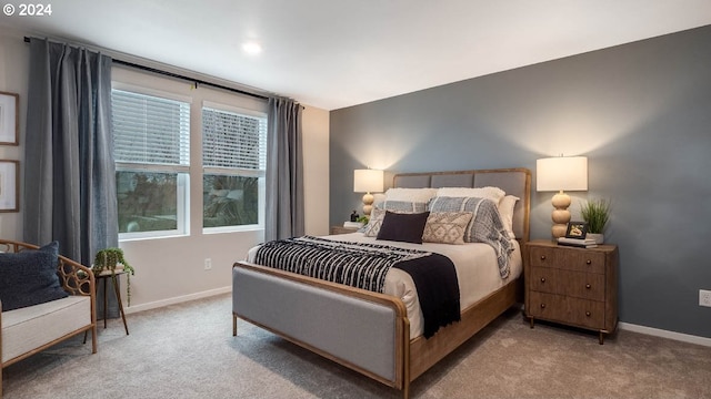 bedroom featuring baseboards and light colored carpet