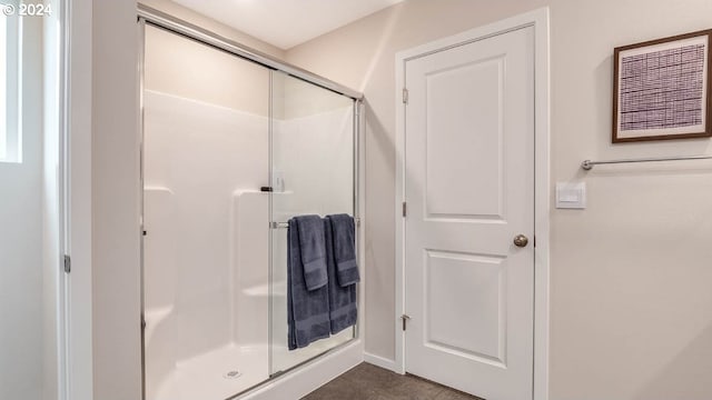 full bath with a shower stall and tile patterned flooring