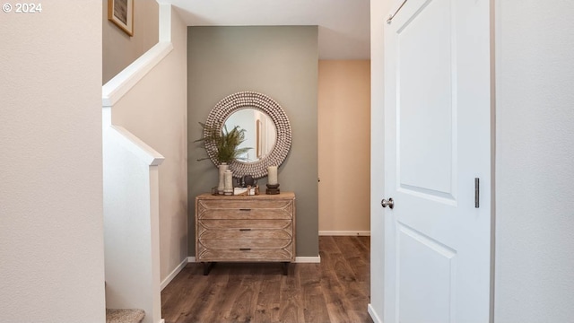 corridor with dark wood finished floors and baseboards