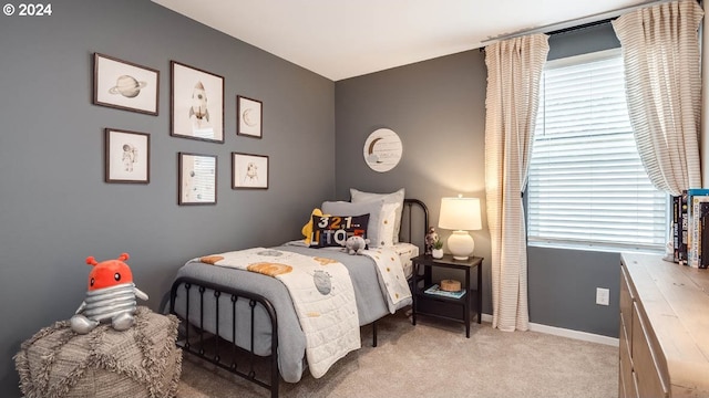 bedroom with baseboards, light carpet, and multiple windows